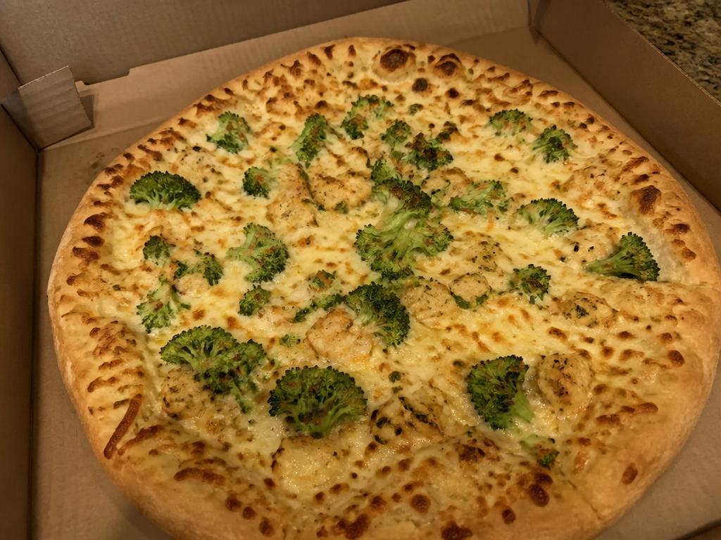 Fertig gebackene Broccoli-Hähnchen-Pizza mit geschmolzenem Gouda im Lieferkarton